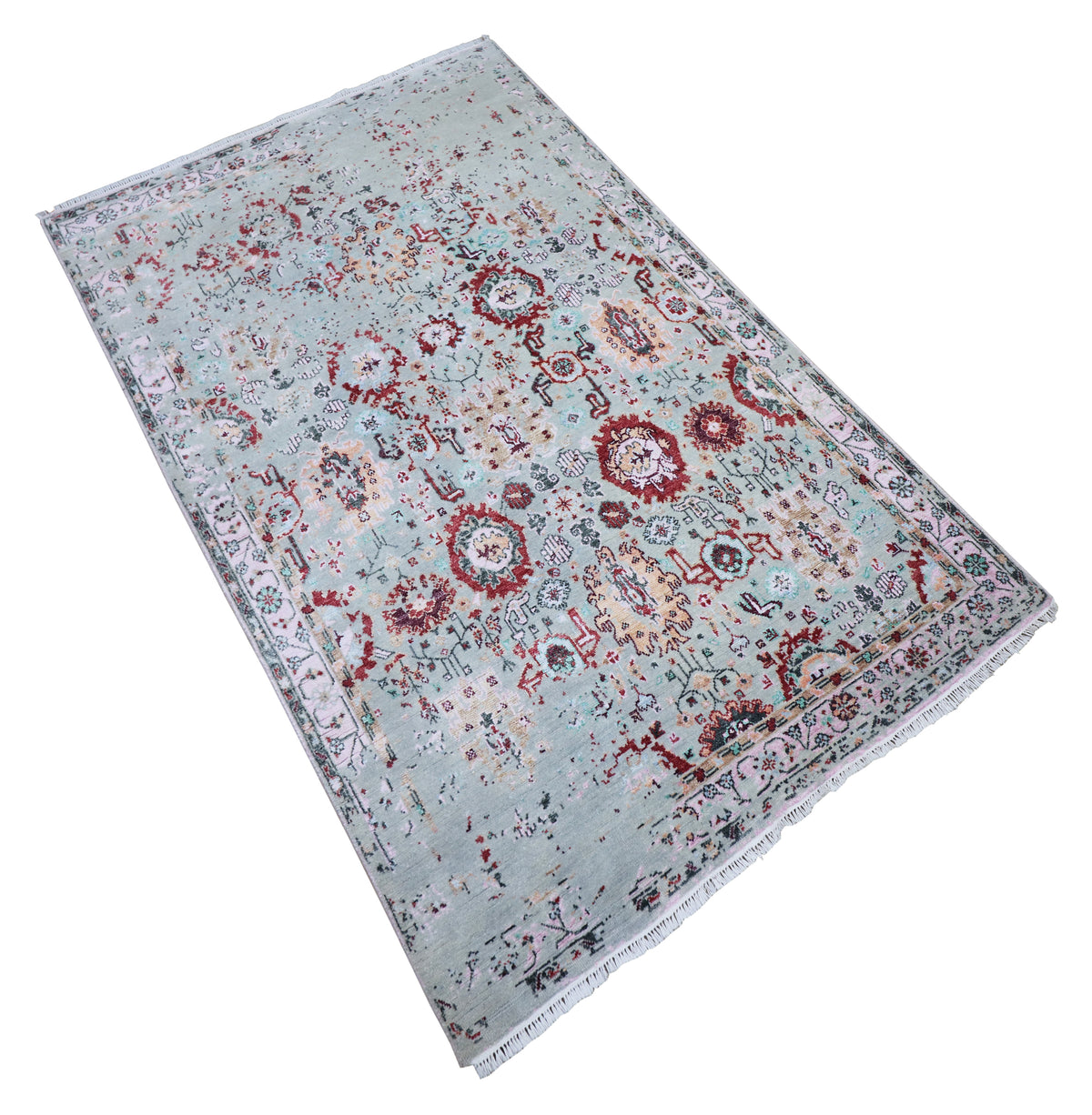 Oushak rug angled view in light blue-gray with red and navy medallion pattern and border trim