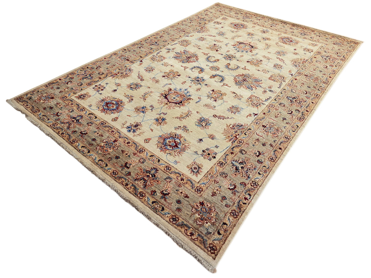 Rectangular area rug with cream background, central medallion, and border of multicolor flowers
