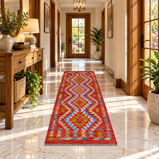 Kilim rug in hallway setting; red and cream chevron pattern with blue and yellow details.