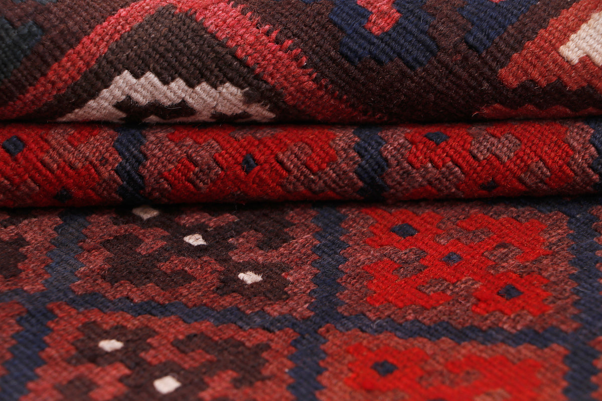 Kilim rug folded edge showing red, black, and navy diamond patterns