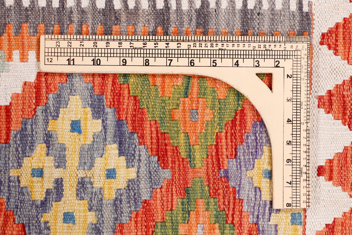 Orange kilim rug with multicolor geometric medallion pattern and fringe edging