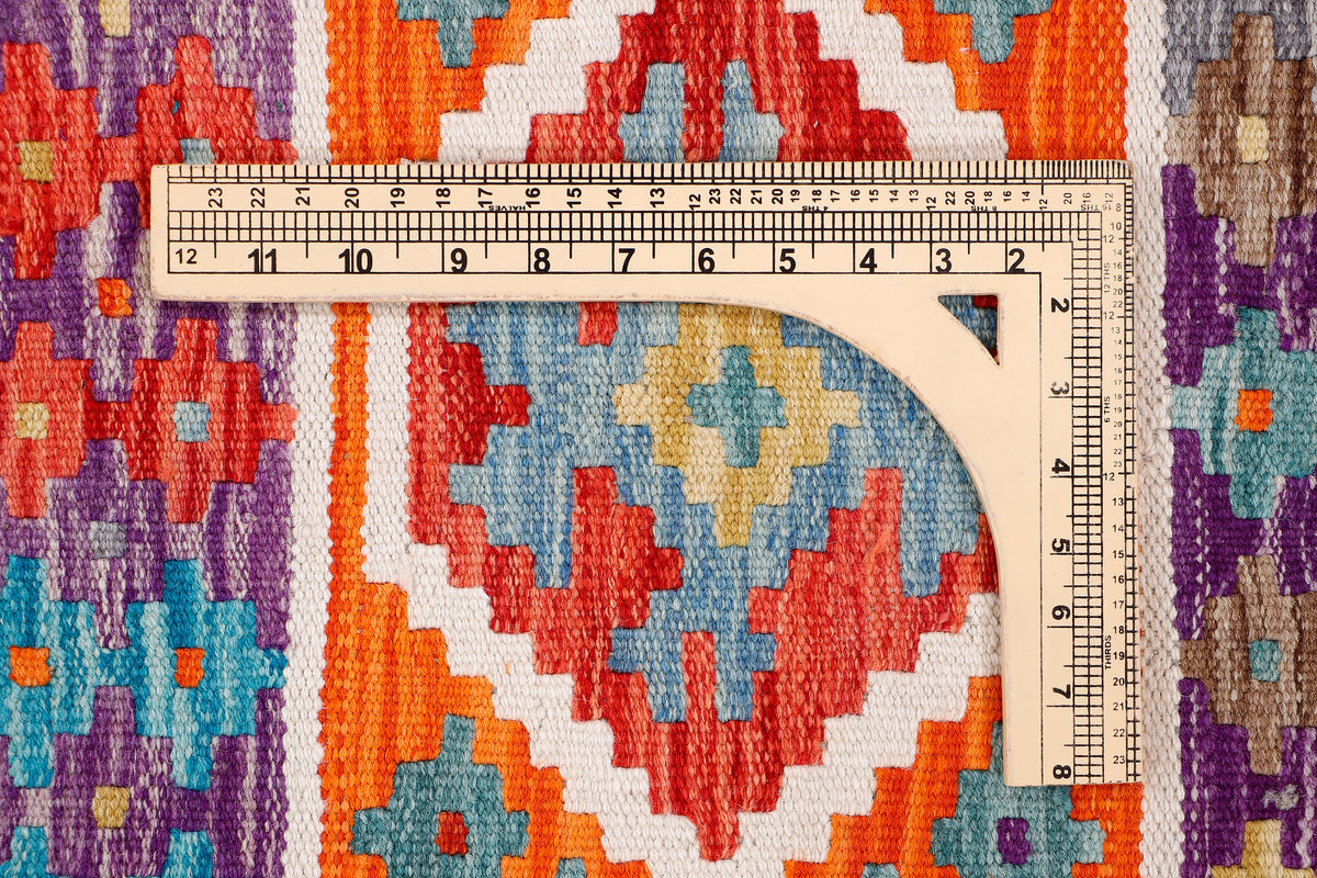 Kilim rug close-up with multicolor geometric design and measuring tape for size check