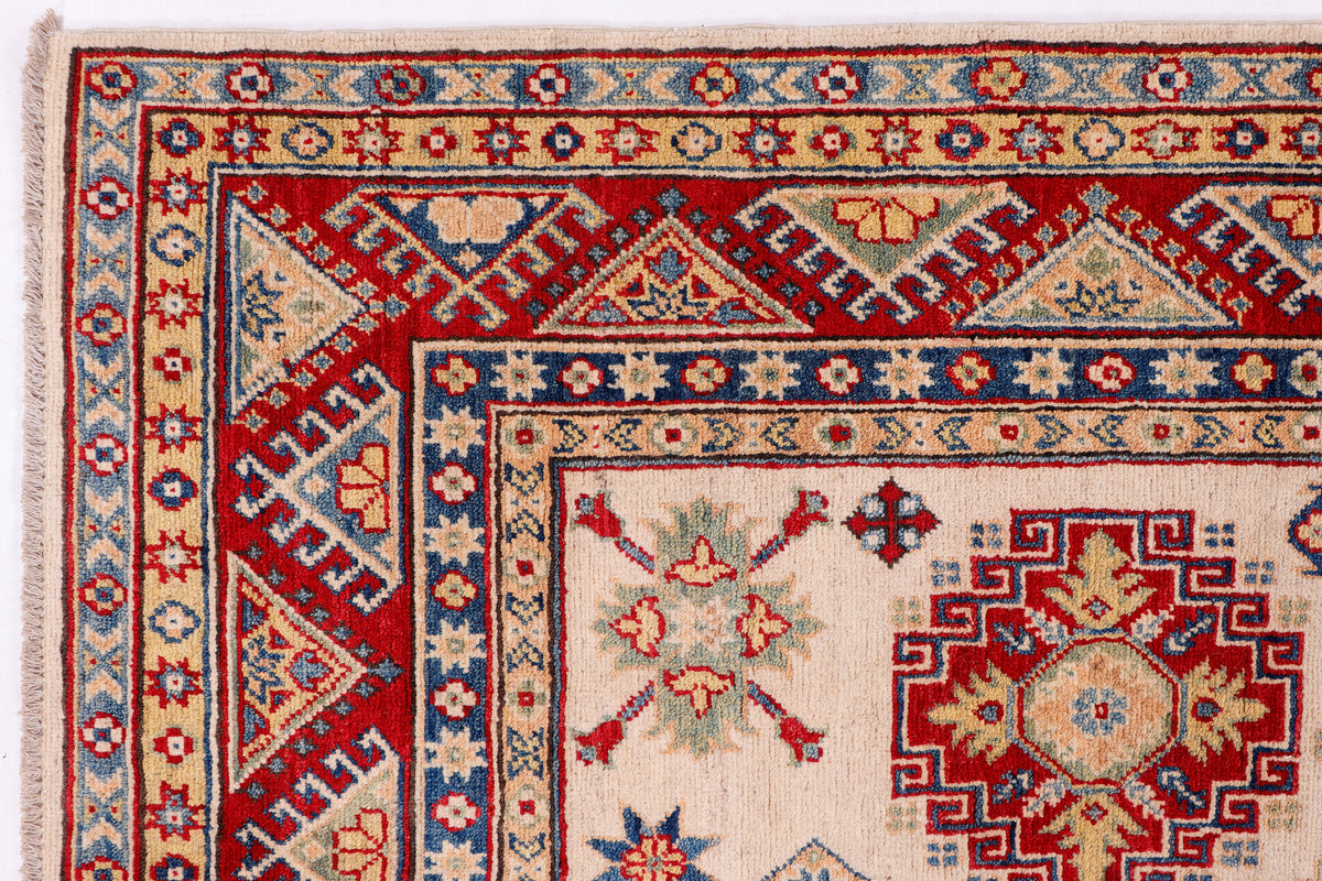 Cream rug with red, navy, and blue patterned border and central medallion motifs