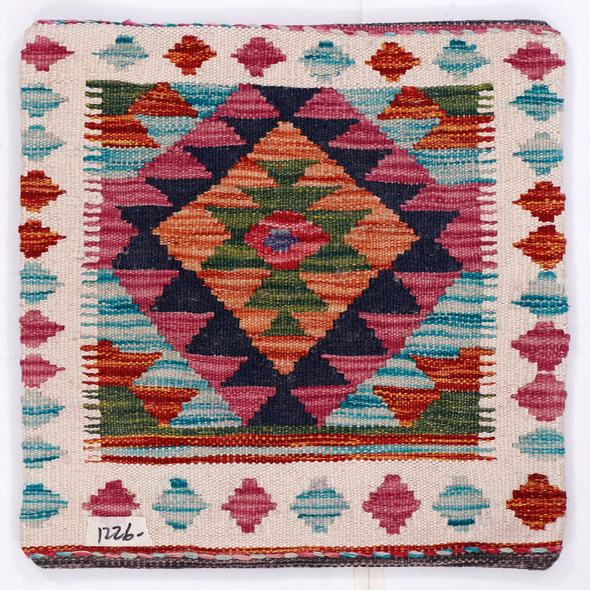 Kilim cushion cover close-up with geometric medallion diamond pattern, fringed edges, 45x45