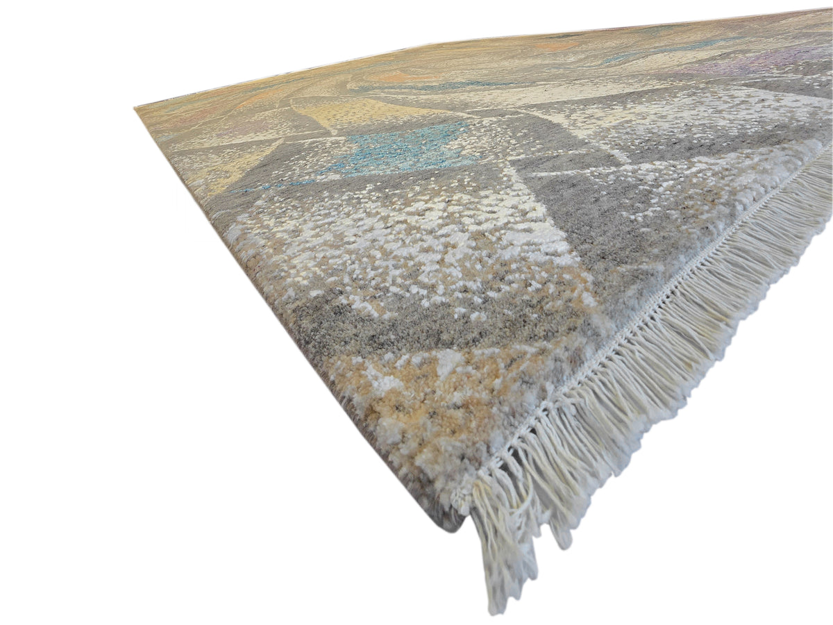 Modern abstract rug with corner fringe and beige-gray swirling design with blue detail