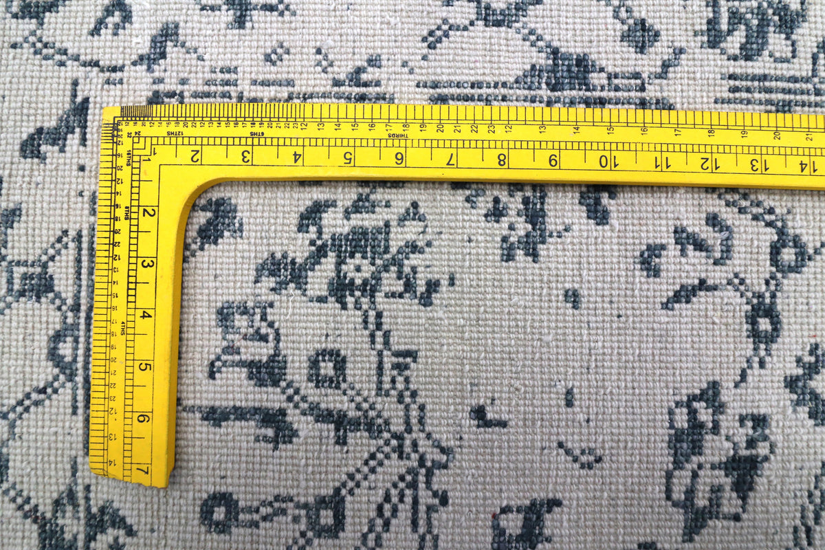 Off-white rug fabric with blue Delft-style floral motifs and ruler detail