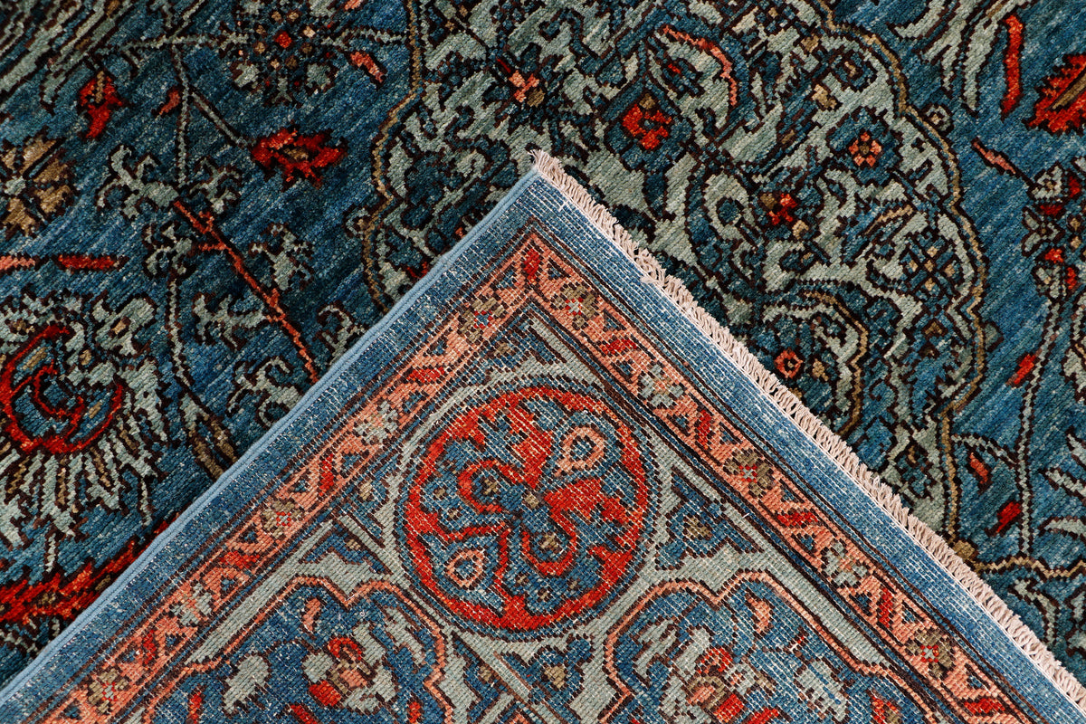 Corner of blue oriental rug with red circular medallion and teal trim