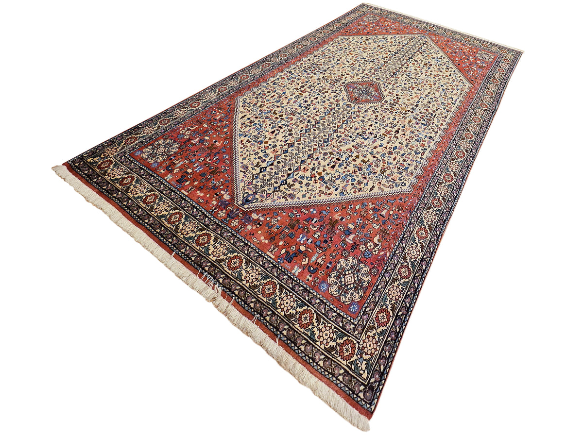 Rectangular area rug with central cream medallion and red geometric field, navy border