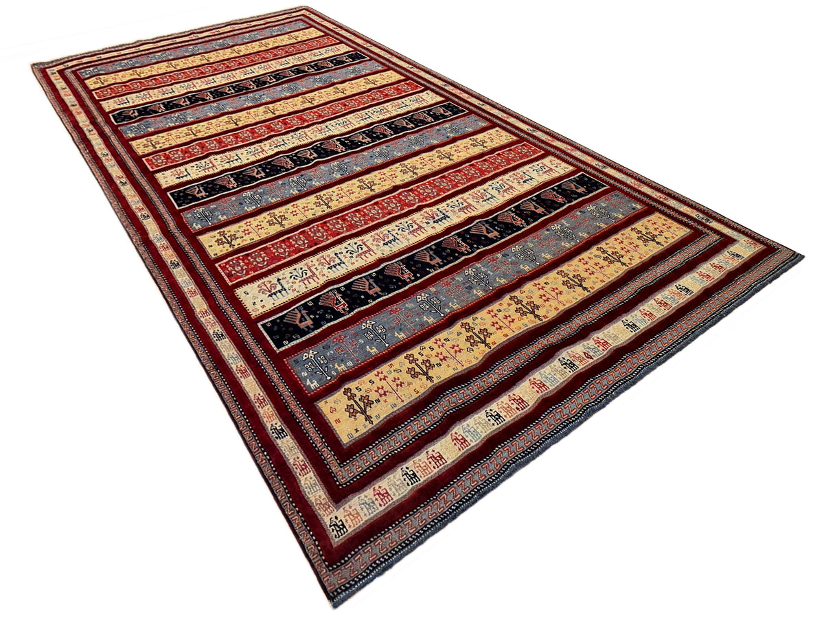 Multicolor area rug with red frame, beige ground, navy bands and repeating motifs