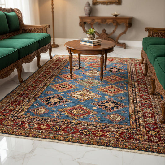 Geometric blue rug with red and rust border, laid flat on the floor.
