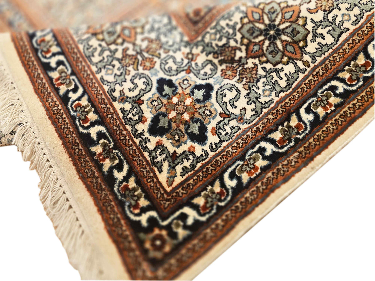 Corner view of a multicolor patterned rug with ornate motifs and fringed edge