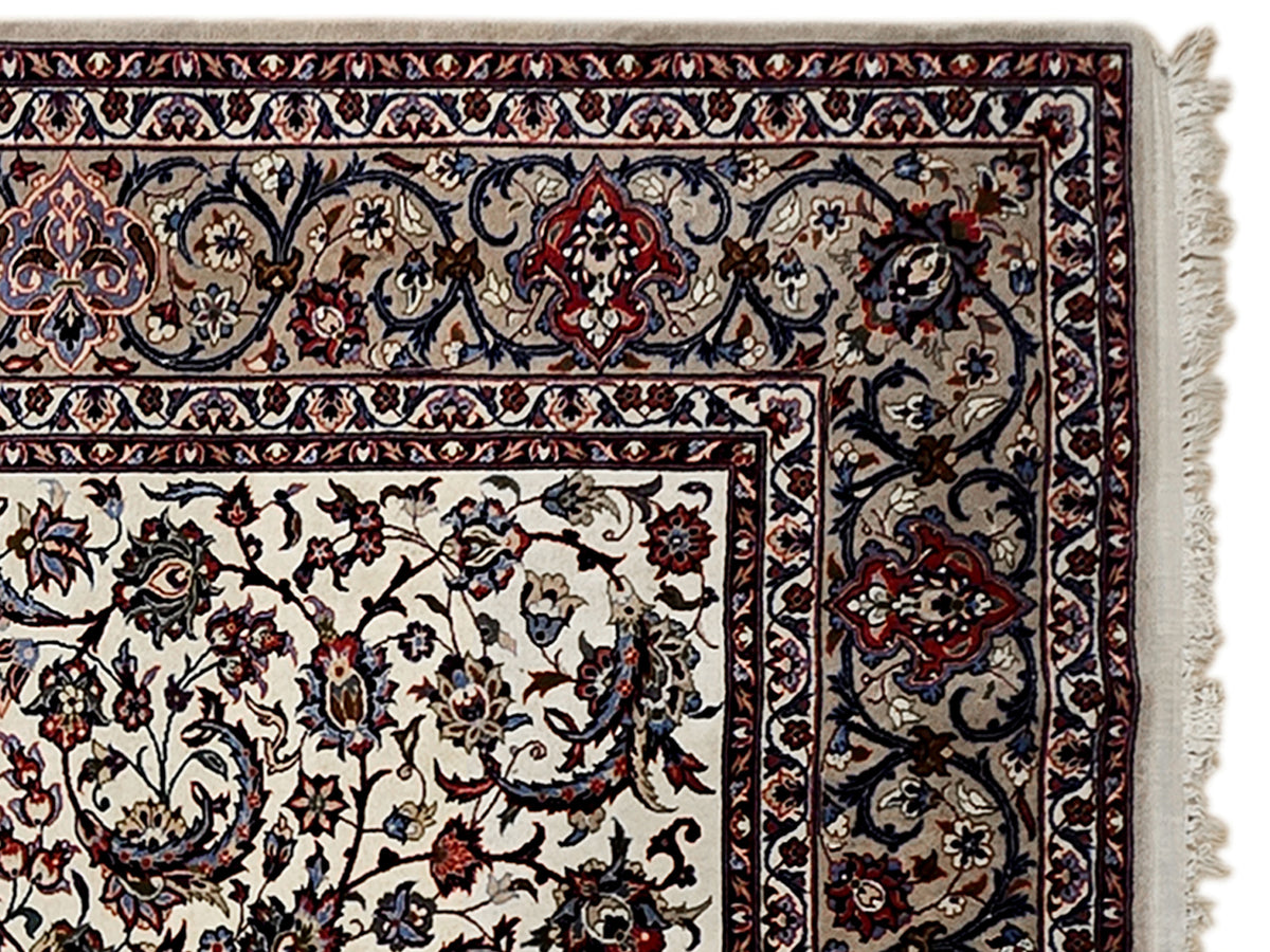 Esfahan perizisch rug border detail with cream background, navy vines, and red floral accents