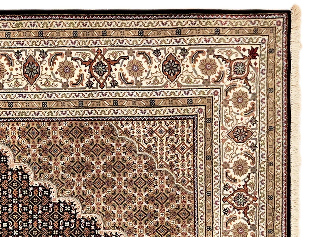 Close-up of Tabriz mahi rug border with cream panels and dark ornamental motifs