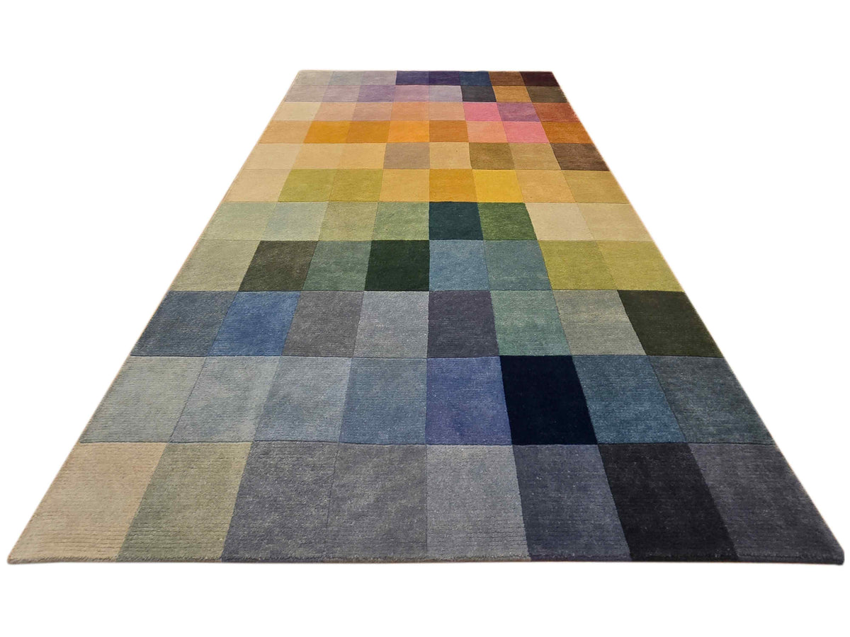 Patchwork rug with square tile pattern in blue, green, yellow, and tan