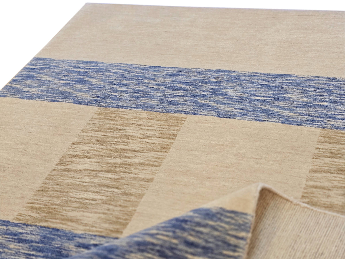 Handloom rug detail: beige panels with blue stripe across woven surface