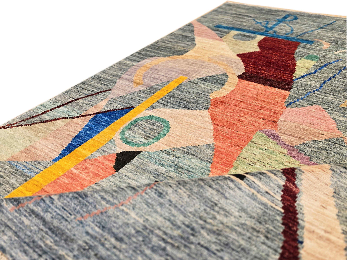 Close-up abstract rug with layered geometric shapes and multicolor lines on gray