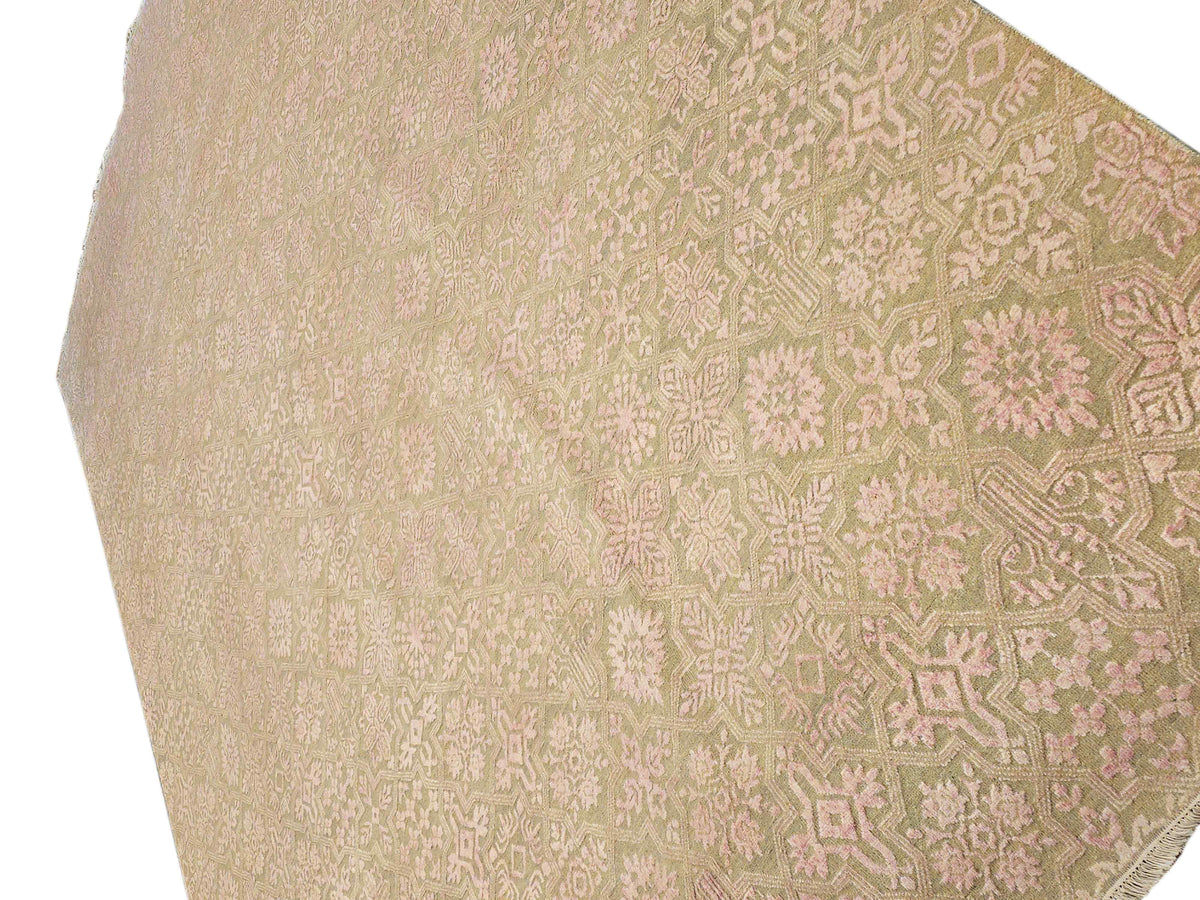 Close-up of beige rug corner with cream and pink geometric floral motifs