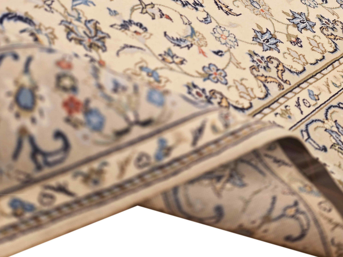 Kashan-style rug texture close-up with blue floral motif and ivory fringe edge