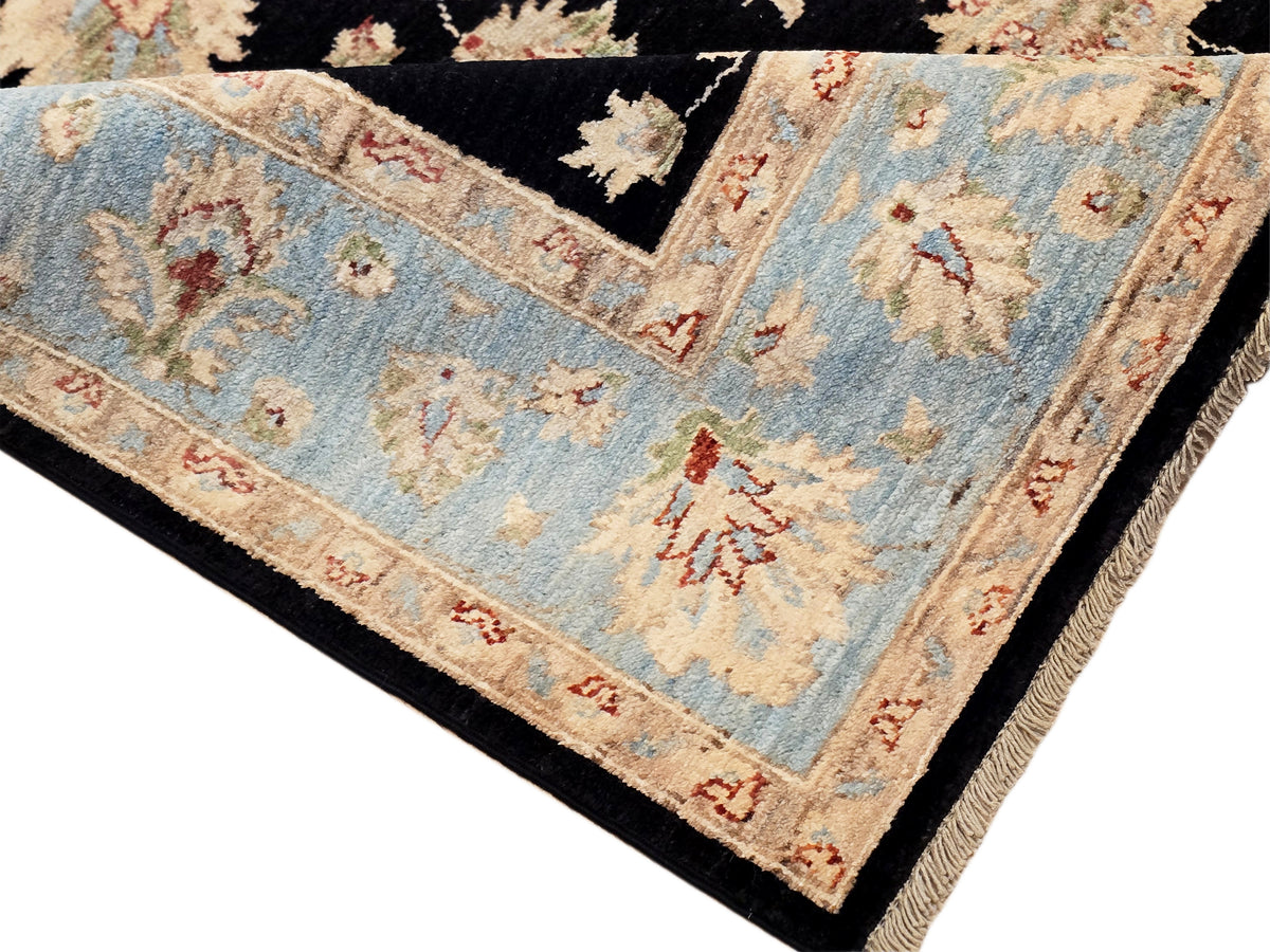 Close-up of rug field in light blue with floral motifs and red-orange edging