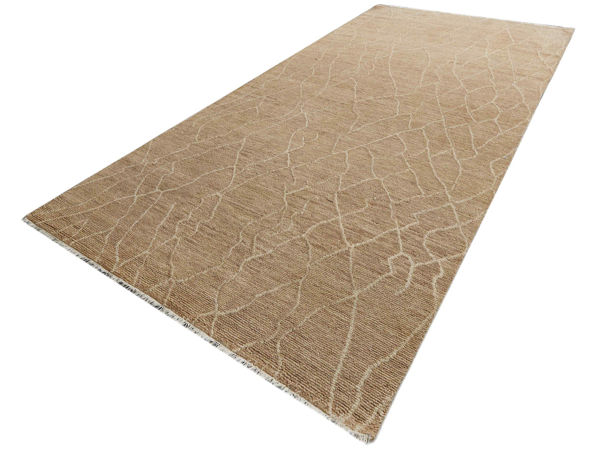 Beige crackle-pattern area rug with stitched border, angled