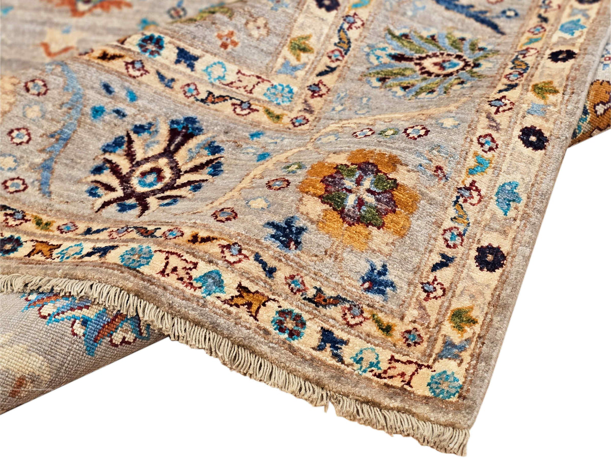 Light beige area rug with ornate floral medallions and blue, red, and navy accents, fringed edge