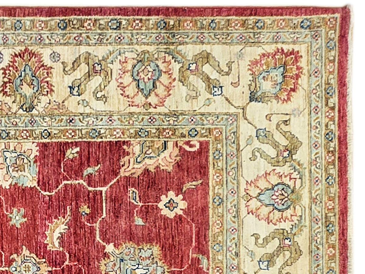 Close-up red and cream rug with detailed floral medallions and patterned border.