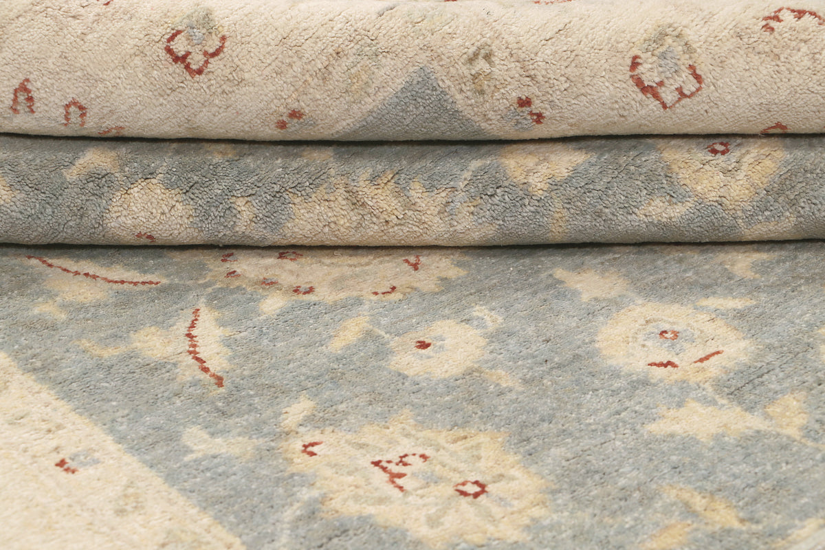 Afghan rug detail of folded pile showing blue field and small red floral accents