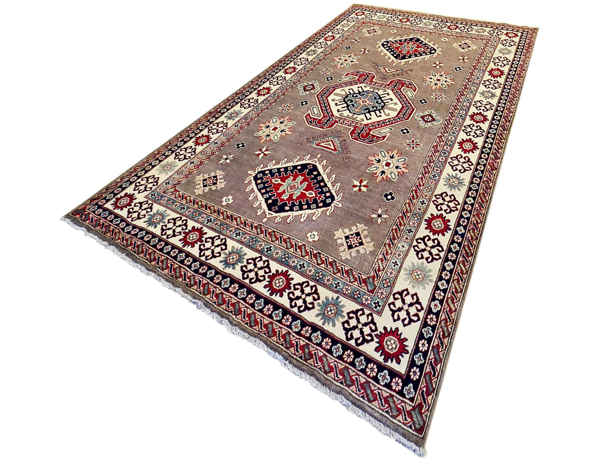 Kazak rug with beige-gray field, red and blue medallion motifs, and fringed border