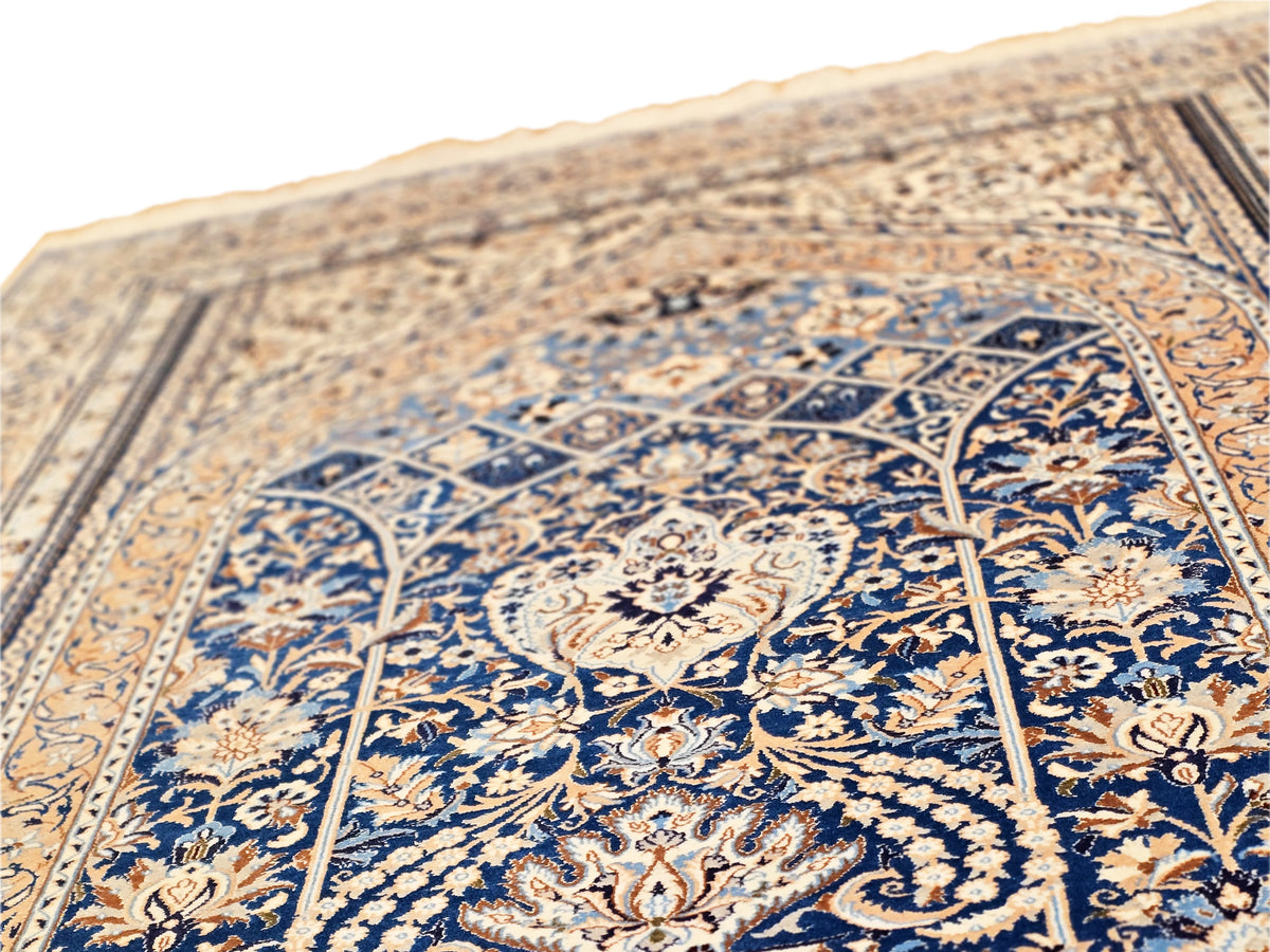 Close-up of blue floral motif rug with tan border and intricate lines