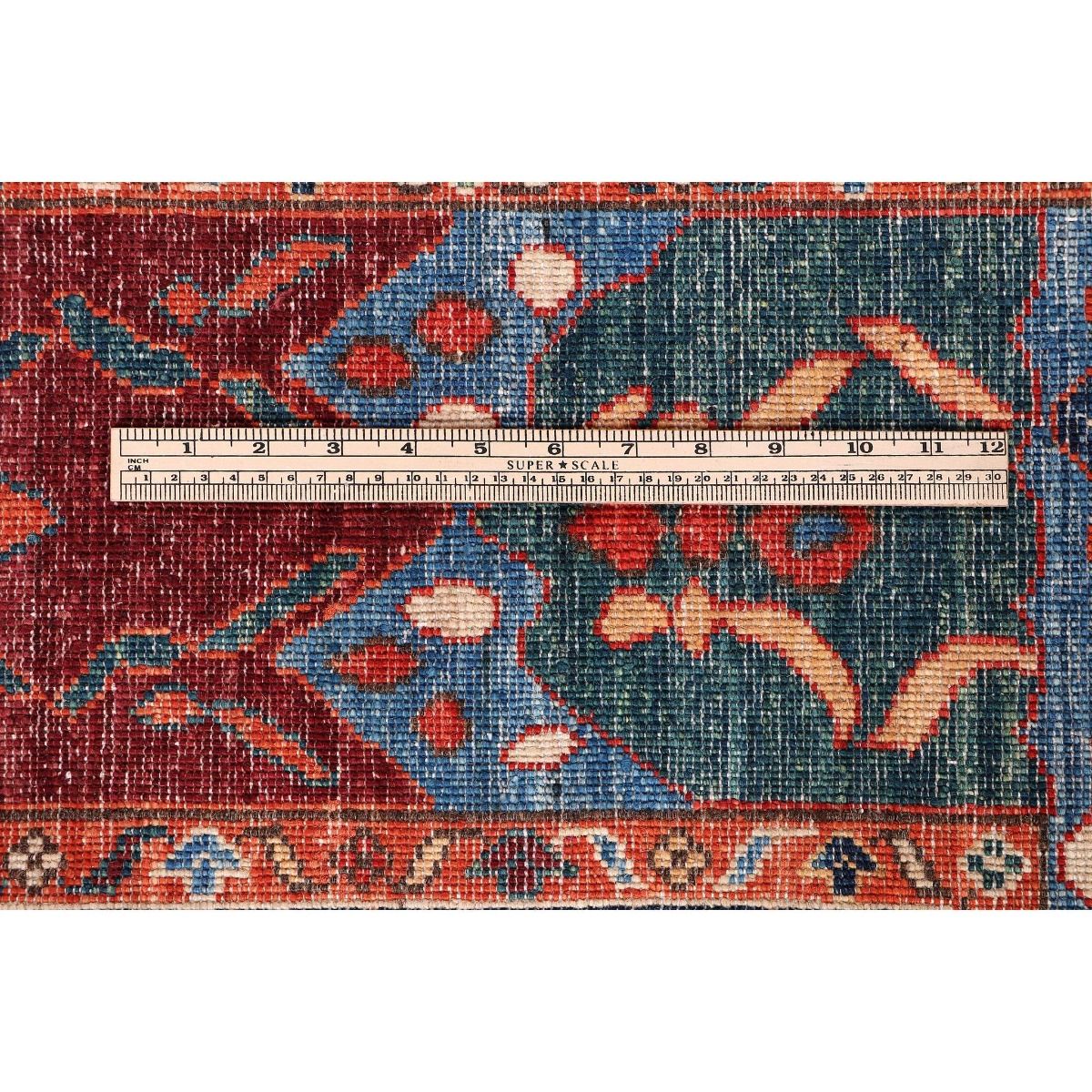 Rug pattern close-up in red, blue, and cream; tape measure shows length and width.