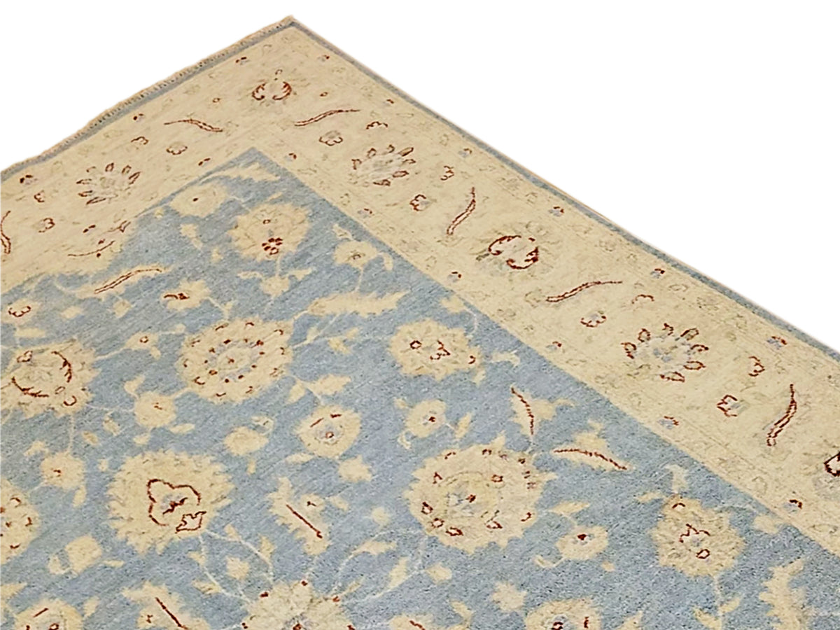 Afghan rug close-up with blue diamond panel and cream border with red ornamental lines