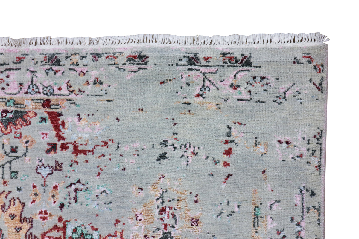 Oushak rug corner with light blue-gray field and red, navy, and beige motif detailing