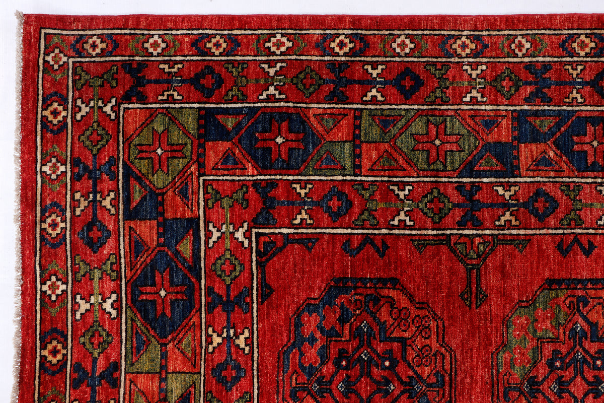 Red rug corner with detailed border bands and diamond motifs