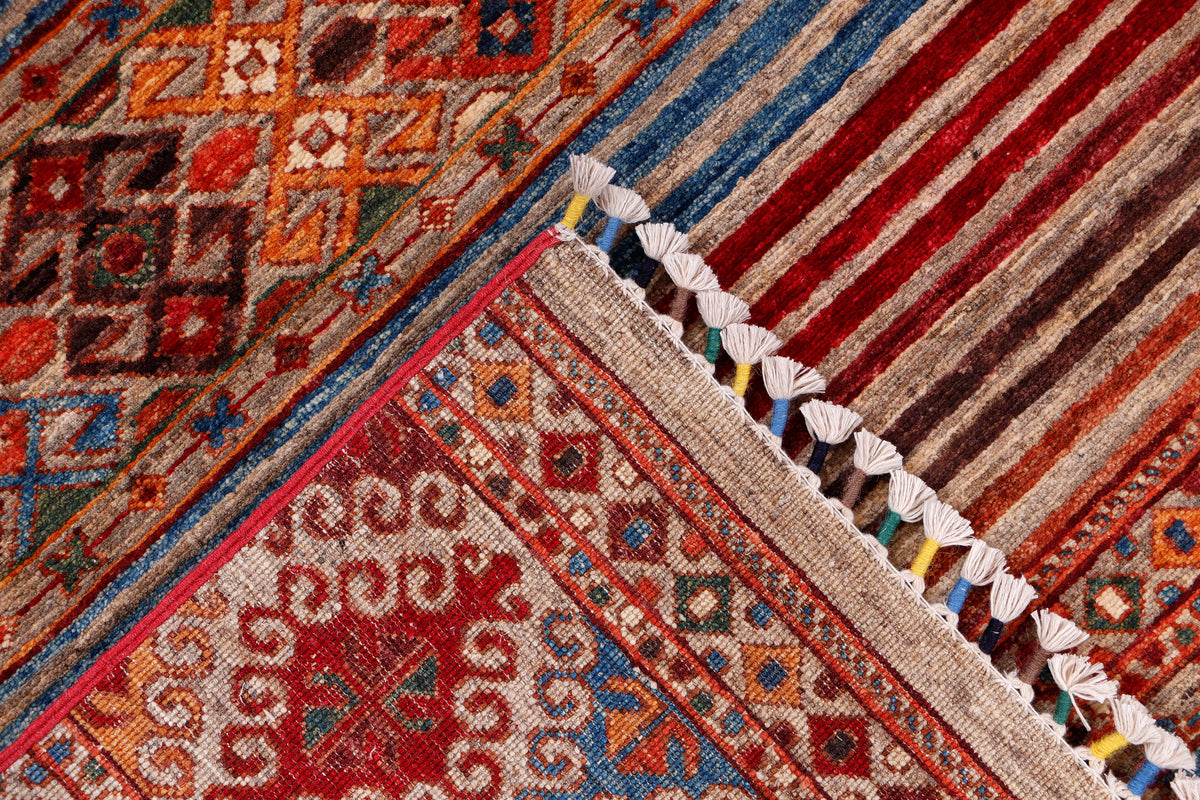 Red and cream geometric rug corner with tassel fringe
