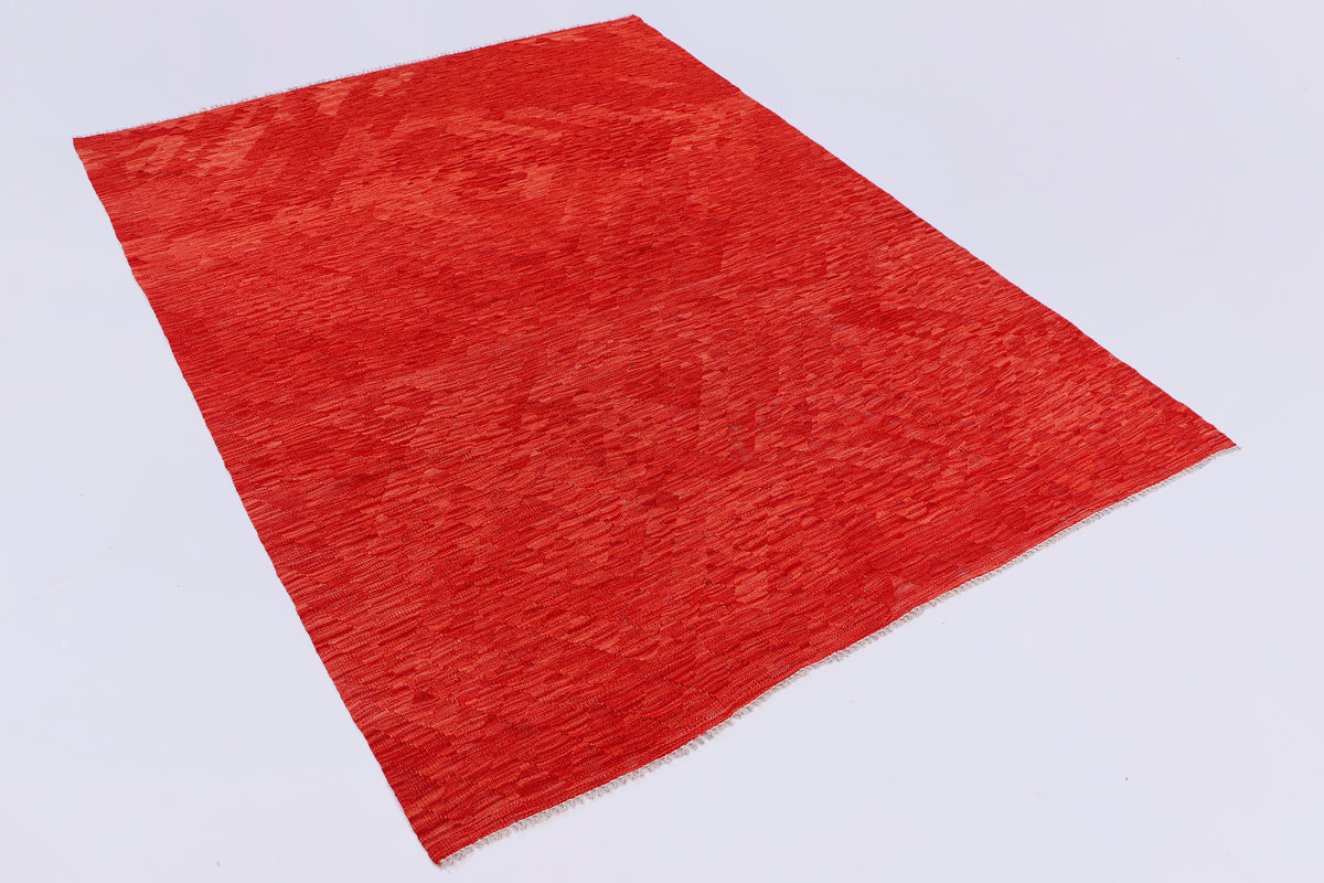 Red kilim rug angled view showing flat woven texture and even surface