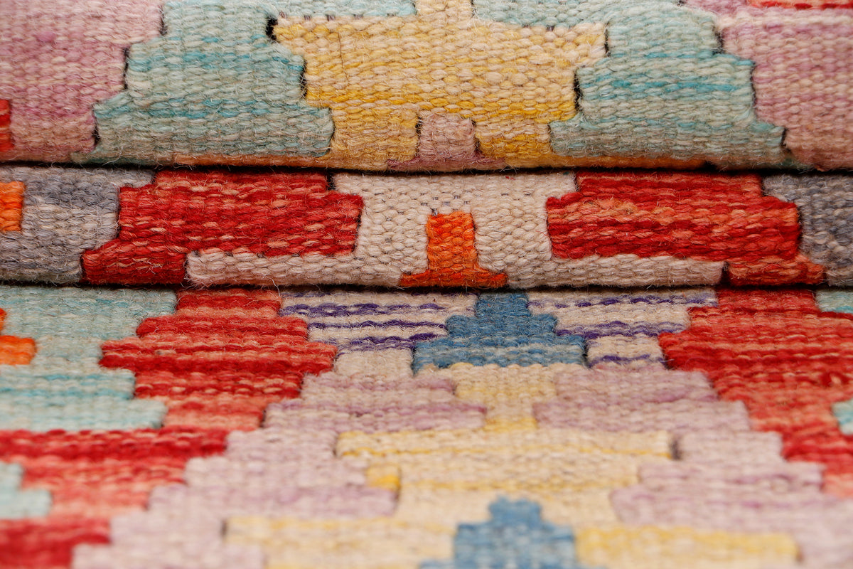 Kilim rug surface close-up showing colorful woven blocks and textured flat weave