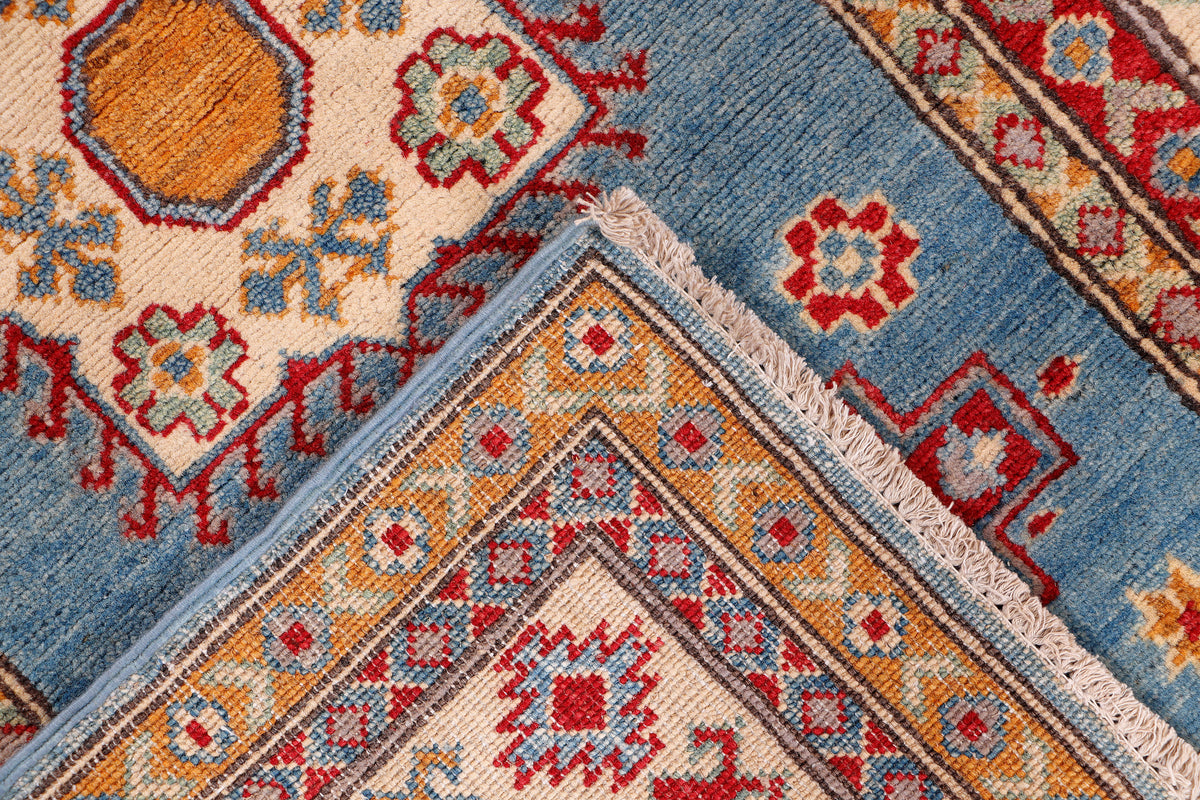 Blue rug corner with orange and red star medallion and decorative border