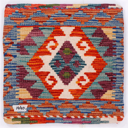 Kilim cushion cover close-up with orange, blue, white, and burgundy geometric medallion