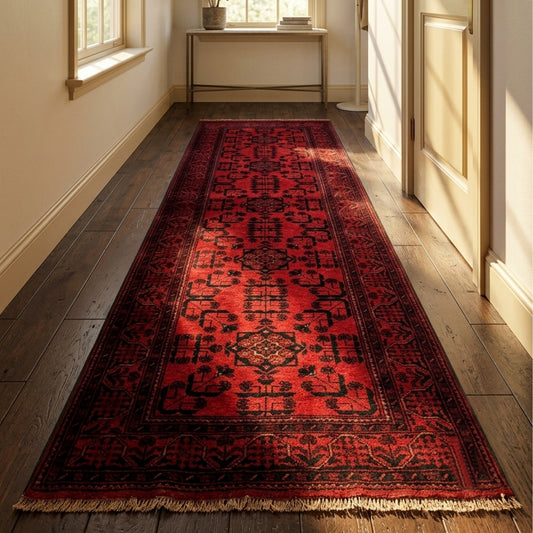 Khanmohamad rug runner in deep red with dark ornate patterns and short fringe ends.