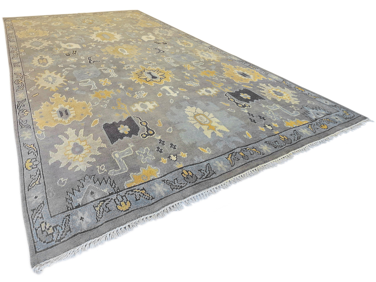 Oushak rug in gray with yellow floral and geometric motifs, fringed corner.