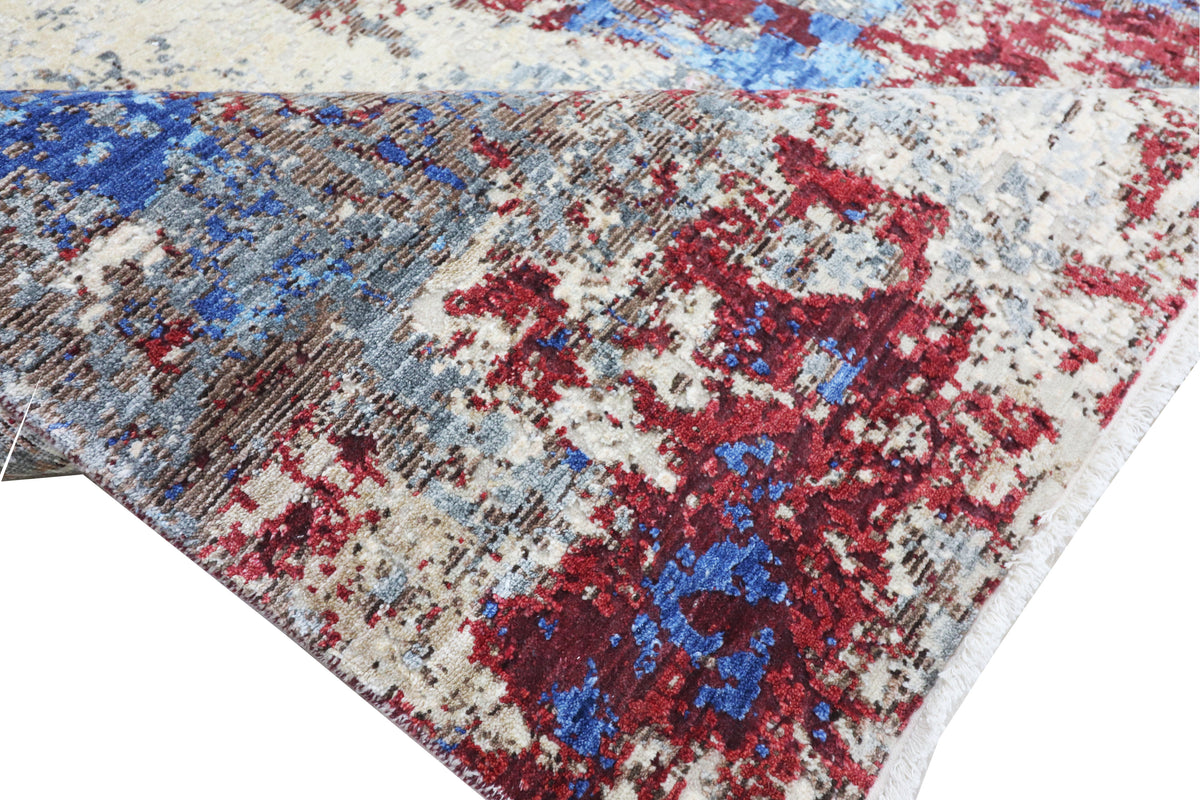 Corner view of abstract rug with blue and crimson distress pattern on off-white