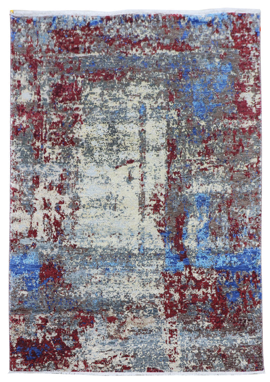 Rectangular abstract rug with off-white base and blue and crimson distressed design