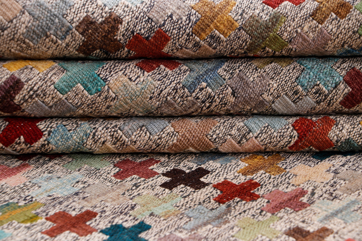 Beige kilim rug edge detail showing folded layers and textured flatweave pattern.