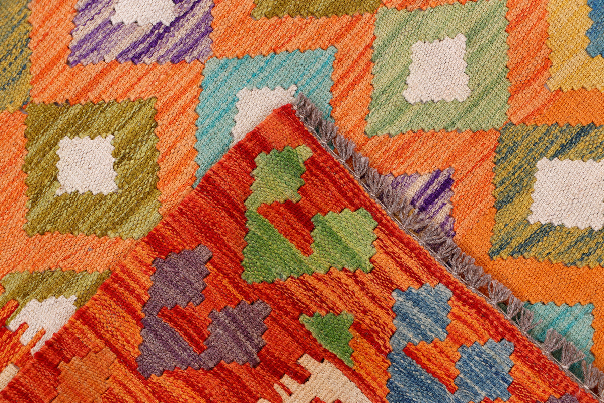 Kilim rug corner with orange base and green, blue, and white geometric squares