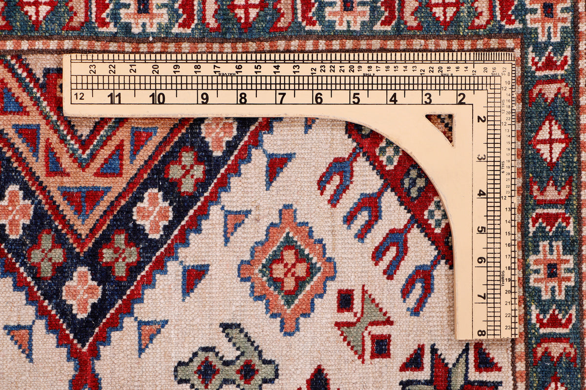 Blue Kazak rug with cream field, red and blue motifs, measurement ruler