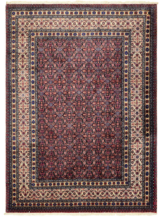 Red and navy patterned area rug with cream border and dense repeating medallions.