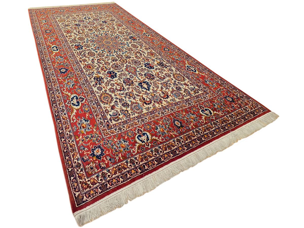 Red, blue, and cream patterned rug with central medallion and fringed trim