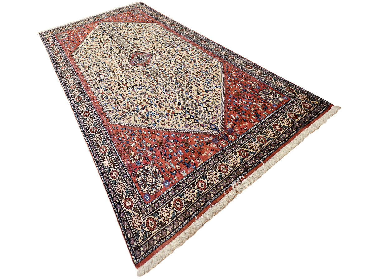 Rectangular area rug with geometric medallion on cream background, red and navy accents