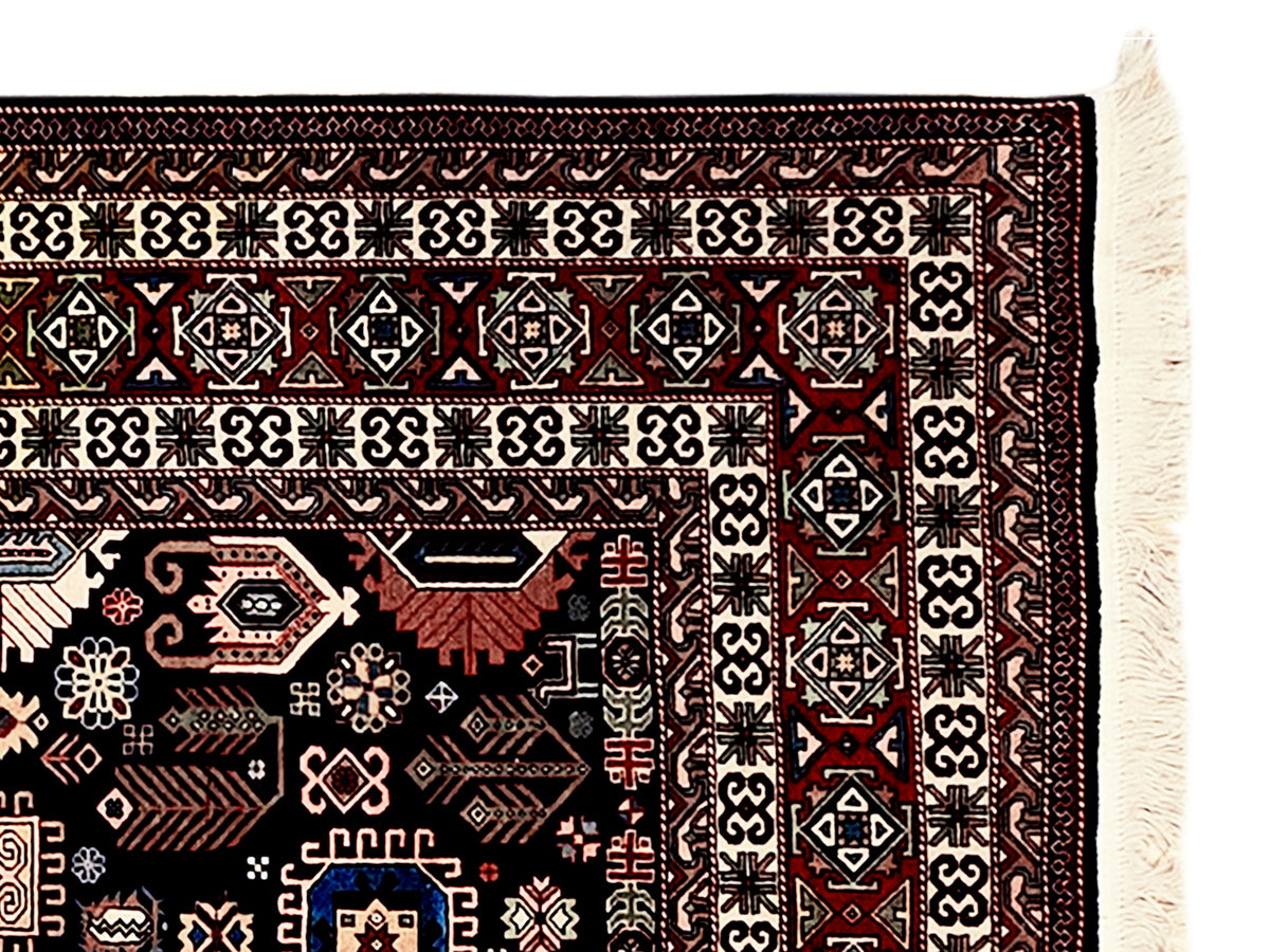 Azerbaijan rug border detail with repeating motifs and cream fringe on dark ground