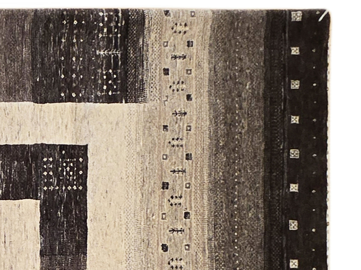 Close-up of geometric rug pattern with beige panels and dark brown textured sections